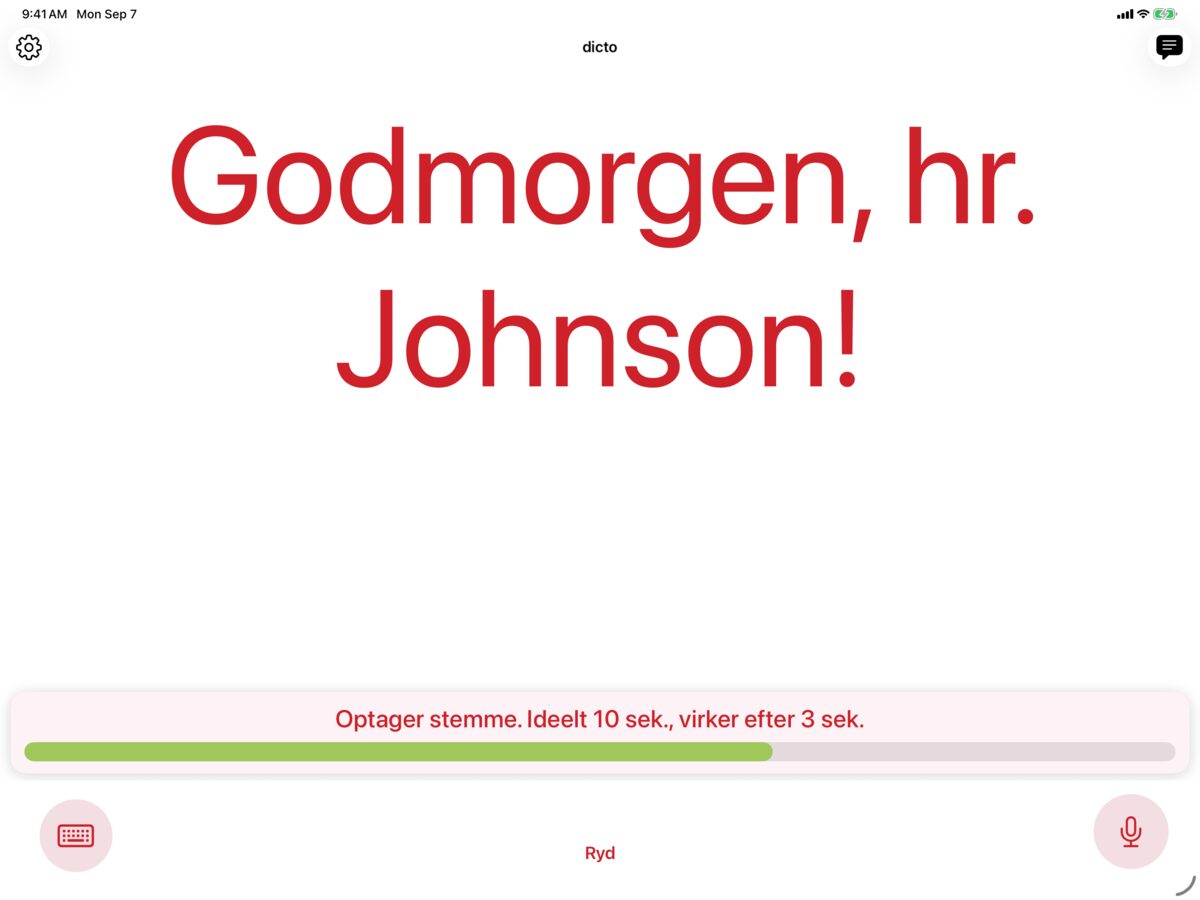 dicto på iPad, der registrerer en stemme med Solo og viser beskeden Godmorgen, hr. Jensen! i karminrød på hvid