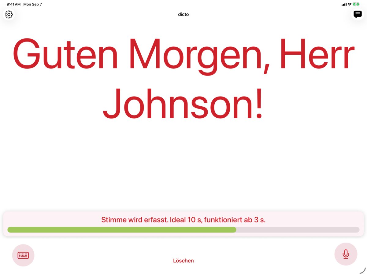 dicto auf dem iPad erfasst eine Stimme mit Solo und zeigt die Nachricht Guten Morgen, Herr Müller! in Purpurrot auf Weiß